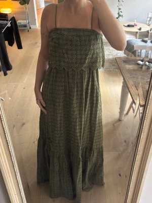 Grön långklänning med broderi - Säljer en grön långklänning med tunna axelband och broderade detaljer. Klänningen är helt ny med prislapp. 2500kr nypris. Storlek S, men står 42 (Italiens storlek) 