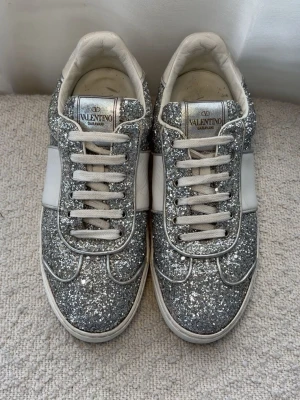 Glittriga sneakers från Valentino - Säljer mina fina glittriga valentino flycrew sneakers i storlek 36. Jag säljer då dom inte riktigt kommer till användning. Jag har använd skorna några fåtal gånger, så de är i mycket bra skick. Hör av er om ni har några funderingar kring skorna eller vill ha fler bilder!💞           