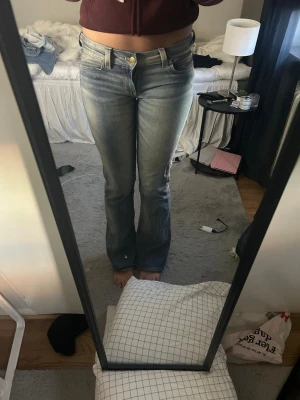 Weekday jeans - Säljer ett par ljusblå bootcut jeans med snygga slitningar och klassisk femficksmodell. Jeansen har en guldfärgad knapp och är tillverkade i ett mjukt denimtyg med lite stretch. Perfekta för en avslappnad och trendig look. Pris kan diskuteras 💗