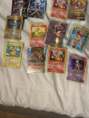 Samling Pokémonkort blandade motiv - Säljer en samling Pokémonkort med olika motiv som Charizard, Mewtwo, Pikachu och fler. Flera kort har holografisk effekt och vissa är i plastfickor. Perfekt för dig som gillar Pokémon eller vill utöka din samling.   PRISET KAN DISKUTERAS. Vill bara få sålt