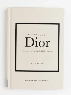 Lilla boken om Dior av Karen Homer - En stilren bok med hårdpärm i vitt, 'Lilla boken om Dior' av Karen Homer. Boken berättar historien om det ikoniska modehuset Dior och är perfekt för dig som älskar mode och design. Omslaget har svart text och ram, vilket ger en lyxig känsla.