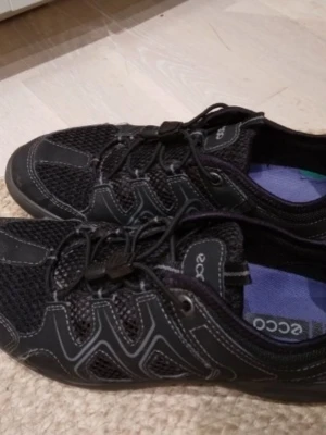 Ecco Terracruise LT, Svarta Promenadskor, dam,Strlk 38. Fint skick. - Ett par svarta dam promenadskor från Ecco "Terracruise LT", Storlek 38, med snabbsnörning. Skorna har en ventilerande ovandel i mesh och en robust sula. Ganska lätta men ända hållbara/bra kvalitet. Perfekta för promenader och/eller som rese eller jobbskor. Lätta att ta på och av. Fint skick, nästintill helt nya. Har endast använts inomhus vid jobb fåtal ggr, aldrig utomhus. Nypris 1'200 kr.