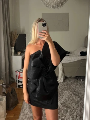 Svart one shoulder klänning med rosett - Otroligt fin klänning från H&M med en stor rosett. 