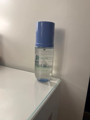 CK One Coconut parfym 100 ml - Fräsch parfym från Calvin Klein, CK One Coconut, i en genomskinlig flaska med blått lock. Flaskan rymmer 100 ml och har en enkel, modern design. Perfekt för dig som gillar tropiska dofter och stilren look på parfymhyllan.