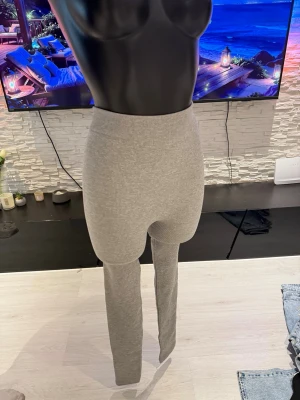 Grå ribbade leggings med hög midja - Snygga grå leggings med ribbad struktur och hög midja. De är tighta och stretchiga, perfekta för en trendig och bekväm look. Passar till både oversized tröjor och crop tops. Materialet känns mjukt och följsamt mot huden.