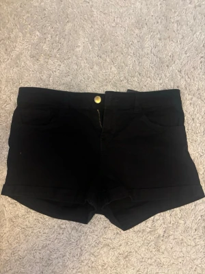 Svarta shorts med uppvikta ben - Snygga svarta shorts med uppvikta ben och klassisk femficksdesign orginalt från hm. Lite högmidjade, storlek 160