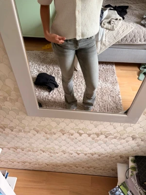 Low waist bootcut jeans - Säljer ett par gråa bootcut jeans med låg midja och klassiska fem fickor. Jeansen har en lätt tvättad look och sitter tight upptill med utsvängda ben. Perfekta för en avslappnad och trendig stil.