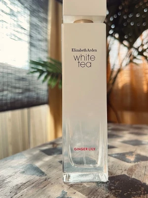 Elizabeth Arden White Tea Ginger Lily Edt, 100ml - Fräsch parfym från Elizabeth Arden i serien White Tea, doften Ginger Lily. Flaskan är hög och fyrkantig i glas med vit och transparent design samt text i svart och rött. Snygg minimalistisk look som passar perfekt på sminkbordet.