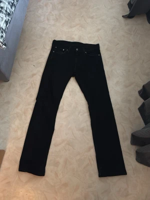 Levis 527 - Säljer ett par svarta jeans med klassisk femficksmodell och slim bootcut . Jeansen har knappgylf och bälteshällor. Passar perfekt till en avslappnad och stilren look. Materialet är denim med lite stretch.