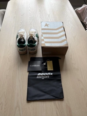 Golden goose ballstars sneakers  - Snygga vita sneakers från golden goose med gröna detaljer och en grön stjärna på sidan. Skorna har beige snörning, grön hälkappa. Medföljer originalkartong, certifikat och dustbag. Perfekta för dig som gillar en sportig och trendig look.