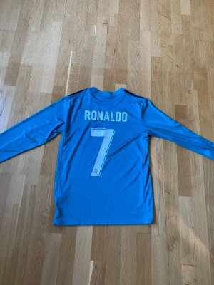 Real Madrid långärmad 2018 Ronaldo - Real Madrid långärmad tröja från 2018 med Ronaldo #7 på ryggen. ⚽️  Storlek: S Skick: bra  Äktheten är inte verifierad, så den säljs i befintligt skick. Skriv gärna om du vill ha fler bilder eller mått!