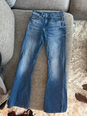 Blå bootcut jeans Noisy May - Säljer ett par blå bootcut jeans från Noisy May. Har klassisk femficksdesign. Jeansen har en något utsvängd passform nedtill och är tillverkade i denim med en tvättad look. Perfekta för dig som gillar retrostil och vill ha ett par bekväma jeans.