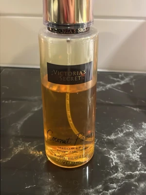 Victoria's Secret Coconut Passion mist - Fräsch body mist från Victoria's Secret i doften Coconut Passion. Flaskan är genomskinlig med guldigt lock och svart etikett. Innehåller 250 ml och har en tropisk, söt kokosdoft. Perfekt för dig som gillar fruktiga och somriga parfymer. 65% kvar ungefär i flaskan!