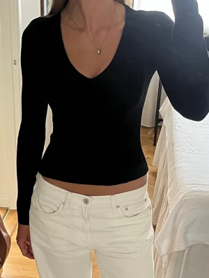 Svart ribbad v-ringad topp NA-KD - Säljer en svart ribbad topp från NA-KD i storlek S. Toppen har v-ringning, lång ärm och en tight passform som sitter figurnära. ❣️Använd 1 gång.