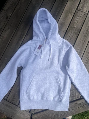 Ljusgrå russemerch hoodie - Snygg russemerch hoodie som är helt ny med prislapp kvar, är i storlek m herr råkade köpa två när jag skulle beställa present åt min kille