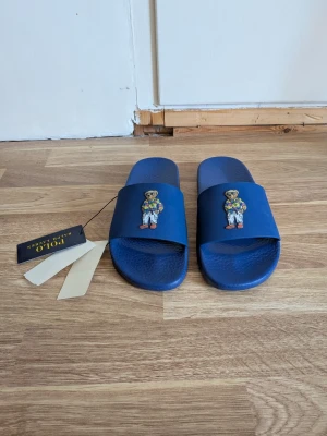 Ralph Lauren tofflor - Tjena, jag säljer en riktigt snygg Ralph Lauren tofflor! Dem är helt nya och har tagsen kvar☺️ Den är självklart äkta✅ Skicka om du har några frågor😄