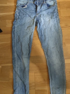 Ljusblå H&M Divided skinny jeans strl 36 - Säljer ett par klassiska ljusblå skinny jeans från H&M (Divided) i storlek 36. Perfekt basplagg med mycket skön stretch som formar sig fint. Fint begagnat skick!