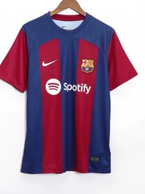 Barcelona matchtröja Nike blå/röd - Säljer en Barcelona matchtröja från Nike i blått och rött med breda vertikala ränder. Tröjan har klubbmärke, Nike-logga och Spotify-tryck på bröstet samt UNHCR-tryck på ryggen. Klassisk rund hals och korta ärmar. Perfekt för fotbollsträning eller match.