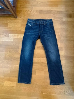 Mörkblå jeans från Diesel - Snygga mörkblå jeans från Diesel med klassisk femficksmodell och raka ben.  Storlek 30/30 