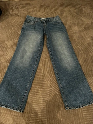 Blå  low wide jeans - Säljer ett par blåa jeans med low wide och riktigt vida ben. Perfekta för en avslappnad och trendig look.
