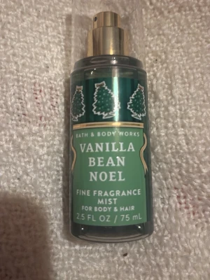 Vanilla Bean Noel doftmist 75 ml - En grön doftmist från Bath & Body Works med motiv av små granar och guldfärgad spraydel. Doften heter Vanilla Bean Noel och flaskan rymmer 75 ml. Passar både kropp och hår och har en söt, vaniljig ton.