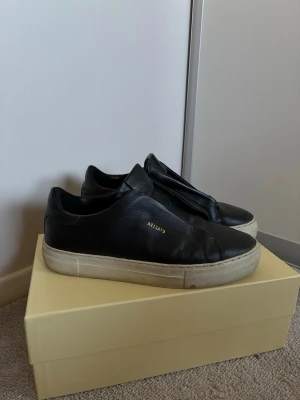 Svarta sneakers från Axel Arigato - Säljer ett par svarta sneakers från Axel Arigato i slät läder med vit, tjock sula. Super snygga! 