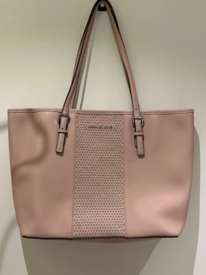 Väska i äkta skinn från Michael Kors - Använd en gång!! Så i jätte fint skick! Finns några mini märken om man granskar noga, se närbilder.  Väskan har två axelband, silverfärgade detaljer och en mittpanel med små nitar som ger en cool touch. Tillverkad i äkta skinn och rymmer allt du behöver till skolan eller stan. Färgen stämmer bäst med bilden som är tagen utomhus. Nypris var över 3000;-