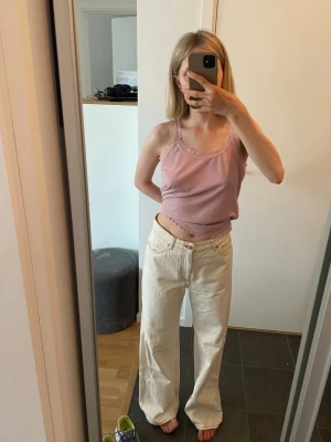 Vida cremefärgade vida jeans från Monki - Säljer ett par cremefärgade jeans från Monki i storlek 36 med raka, vida ben. Jeansen har hög midja och har senapsgula sömmar. 150 kr. 