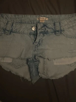 Ljusblå jeansshorts med rå kant - Säljer ett par ljusblå jeansshorts med fransig, rå kant och klassisk femficksdesign. Dom är klippta själva, så dom är lite korta. Köpte för 299kr och säljer för 150kr för att dom är helt nya och säljer för dom är för små! 💕