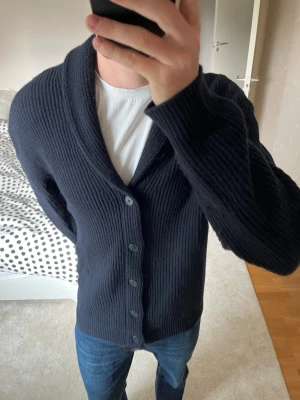 Snygg mörkblå cardigan från Massimo Dutti - En riktigt snygg cardigan från Massimo Dutti tillverkad i tjockt och mjukt material. Cardiganen är i storleken XL utan specifika defekter, lite smått nopprig på sina ställen men går att ta bort med noppermaskin! ——————————————————————————                 📐| Storlek: XL                                                           👖| Märke: Massimo Dutti                                      🔎| Skick: MYCKET FINT!                                                     ✍🏻| Skriv om du har några frågor