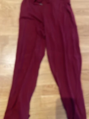 Vinröda leggings med hög midja, chill pants - Snygga vinröda leggings med stretchig passform och bred resår i midjan. Materialet känns mjukt och följsamt, perfekt för en chill och bekväm stil. Passar till oversized tröjor eller hoodies för en avslappnad look.