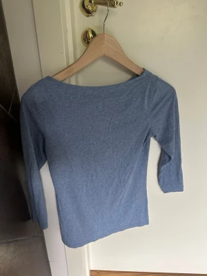 Ljusblå trekvartsärmad topp - En enkel och stilren ljusblå topp med trekvartsärm och rund halsringning. Tillverkad i mjukt bomullsmaterial som känns skönt mot huden. Perfekt att matcha med jeans eller kjol för en avslappnad look.