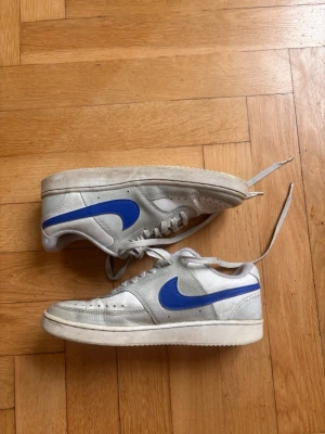 Nike FN0479-001 White/Blue (EU 38.5 / US 6) - Lätt och bekväm modell med mesh‑ovandel och klassisk Nike‑design. Perfekta för vardag, promenader och streetwear. Skorna är använda men i bra skick — lite normalt slitage men inga större defekter. Stilrena, enkla och redo för ny ägare.