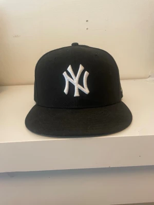 Svart New Era Yankees keps 59FIFTY - Svart new era 59fifty keps i mycket bra skick, endast använd ett fåtal par gånger. Storlek 7 3/8 (58,7 cm). Nypris 500 kr.