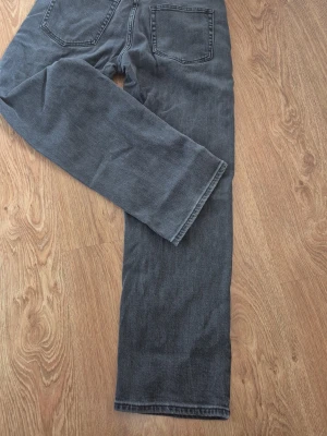 Grå jeans från Lindex, raka ben - Snygga grå jeans från Lindex i storlek 158. Modellen har raka ben och klassiska bakfickor. Tillverkade i mjukt bomullsmaterial som är bekvämt att bära. Perfekta för en avslappnad och trendig look.