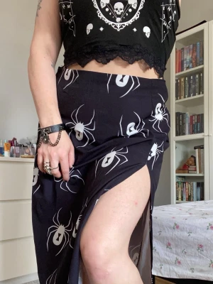 Spindel kjol 🕷️ - Svart kjol med slit, spindelmönster och en dragkedja där bak. Inköpt på Shein i strl XL. Använd flitigt och ganska nött/urtvättad, därav mitt pris. Läs gärna bion innan du gör ett köp.