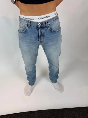 Eleventy jeans  - Säljer ett par ljusblå jeans från Eleventy med rak passform och klassisk femficksdesign. Nypris ca 7000kr. Jeansen har en snygg tvättad look med lätt slitning på framsidan och är tillverkade i denim. Perfekta för en avslappnad och trendig stil.