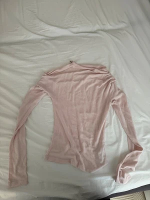 Ljusrosa långärmad topp från Nelly - Säljer en ljusrosa långärmad topp från Nelly. Toppen har en slim passform och är tillverkad i ett mjukt, tunt material som känns skönt mot huden. Perfekt att styla med jeans eller kjol för en enkel och snygg look.