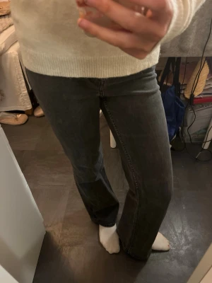 Svarta raka jeans med hög midja - Säljer ett par svarta jeans med rak passform och hög midja. Jeansen har klassisk femficksdesign och är tillverkade i ett mjukt denimtyg. Perfekta för en avslappnad och trendig look.