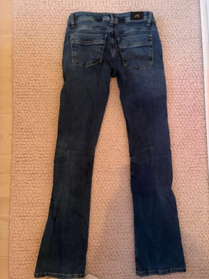 Mörkblå low waist LTB bootcut jeans - Säljer ett par mörkblå bootcut jeans med låg midja klassiska bakfickor och bälteshällor. Jeansen har en lätt tvättad look och raka ben som går ut lite nedtill. Perfekta till en avslappnad stil och passar till det mesta. De har väldigt bra passform och skönt material. Köpta på Zalando för ca. 800kr. Jag har inte använt dem så mycket eftersom att de alltid varit lite för stora. Hör av dig vid frågor🥰🥰
