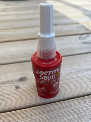 Loctite 5800 tätning - Röd Loctite 5800 flänstätning i plastflaska med vit applikator. Perfekt för tätning av flänsar och packningar. Enkel att använda och smidig att applicera tack vare den smala spetsen.