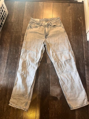 Loose fit ljusblå jeans från H&M - Säljer ett par ljusblå loose fit jeans från H&M. Jeansen har hög midja, raka ben och klassisk femficksdesign. Tillverkade i denim med en avslappnad passform som ger en chill vibe till din outfit.