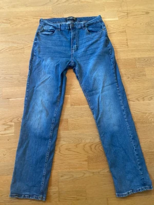 Blåa jeans från On our terms - Säljer ett par blå jeans från On Our Terms i storlek W32/L32. Rak passform med snygg tvättad denim-look. Använda men fortfarande i bra skick utan hål eller större skador. Perfekta till vardags och lätta att matcha.