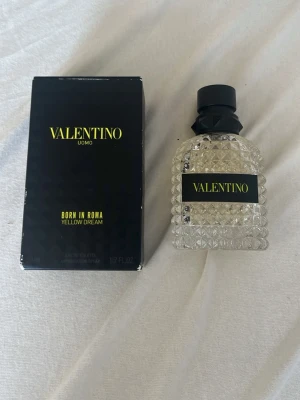 Valentino Uomo Born In Roma parfym - Valentino Uomo Born In Roma Yellow Dream är en parfym med lyxig, transparent glasflaska med nitar och svart kork. Förpackningen är svart med gul text och rymmer 50 ml. Doften är modern och passar dig som vill sticka ut. UNGEFÄR 60-65% KVAR