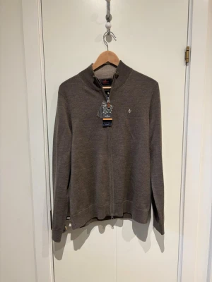 Morris zip i Merinoull - Snygg brun ziptröja från Morris i 100% merinoull. Tröjan är i storlek M och är helt oanvänd! Vid frågor eller funderingar är det bara att höra av sig! 