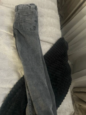 Grå raka bootcut jeans med tvättad look - Snygga grå jeans med rak passform och klassisk femficksdesign. Jeansen har en tvättad finish som ger en cool vintagekänsla. Perfekta att matcha med en hoodie eller t-shirt för en avslappnad stil.