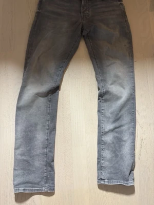 Grå slim fit jeans Slim/Glenn - Snygga grå slim fit jeans med tvättad look och smal passform. Modellen heter Slim/Glenn och har klassisk femficksdesign. Perfekta för dig som gillar en modern och avslappnad stil. Pris kan diskuteras!