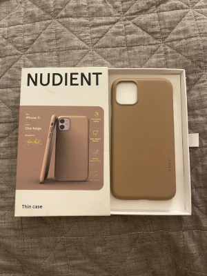 Beige mobilskal NUDIENT iPhone 11 - Snyggt och tunt mobilskal från NUDIENT till iPhone 11 i färgen clay beige. Skalet har en matt finish, är tillverkat i ett slitstarkt material och har inbyggda magneter för trådlös laddning. Perfekt passform och skyddar både kanter och kamera.