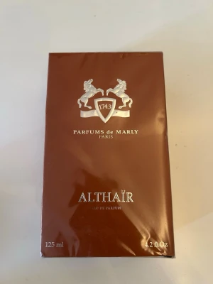 Parfums de Marly Althaïr EdP 125ml - Exklusiv parfym från Parfums de Marly, Althaïr Eau de Parfum i en elegant brun förpackning med silverdetaljer. Flaskan rymmer 125 ml och doften är framtagen i Frankrike. Perfekt för dig som gillar lyxiga och unika dofter.