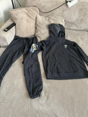 Mörkgrå pyjamas-set med huva - Mysigt tvådelat pyjamas-set i mörkgrått med hoodie och byxor från Victoria’s secret. Byxorna har resår i midjan och vid benslut. Perfekt för chillkvällar hemma. 